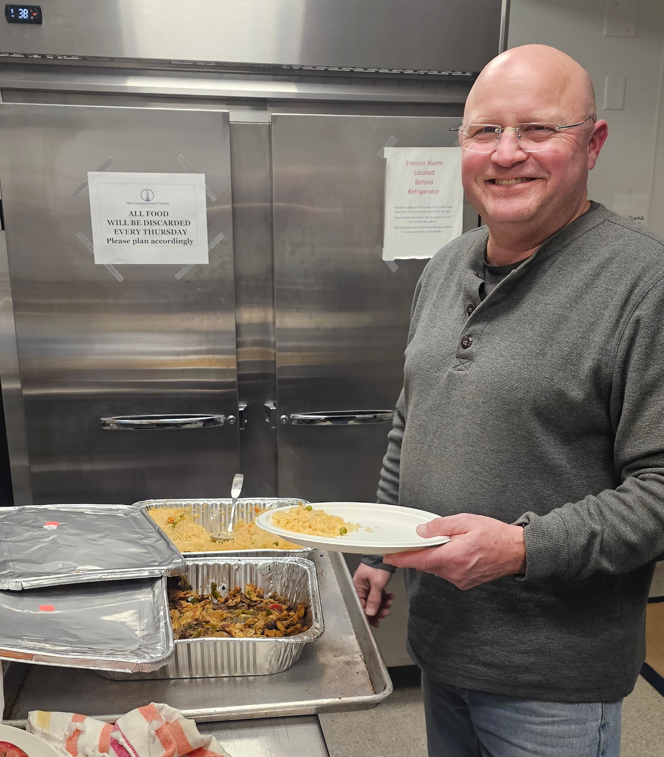 Volunteers serving hot meals to guests at The Warming Place